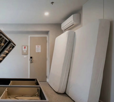 A bedroom with the mattress upright and bed base opened for treatment, from the supplied preparation video